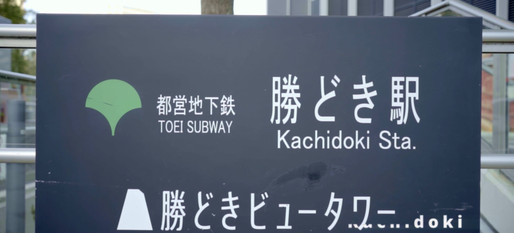 建物と駅の名前が書かれた黒い看板